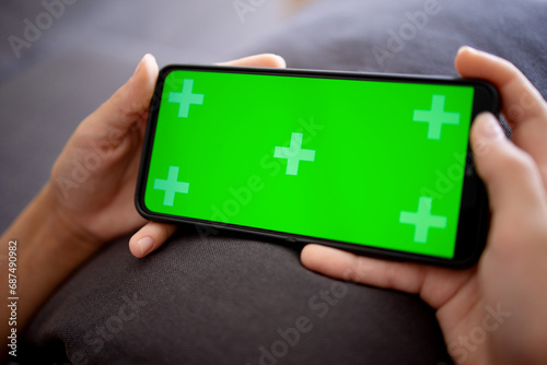 a green phone screen in the hands of a teenage girl. Copy space for advertising and text. Chromakey smartphone