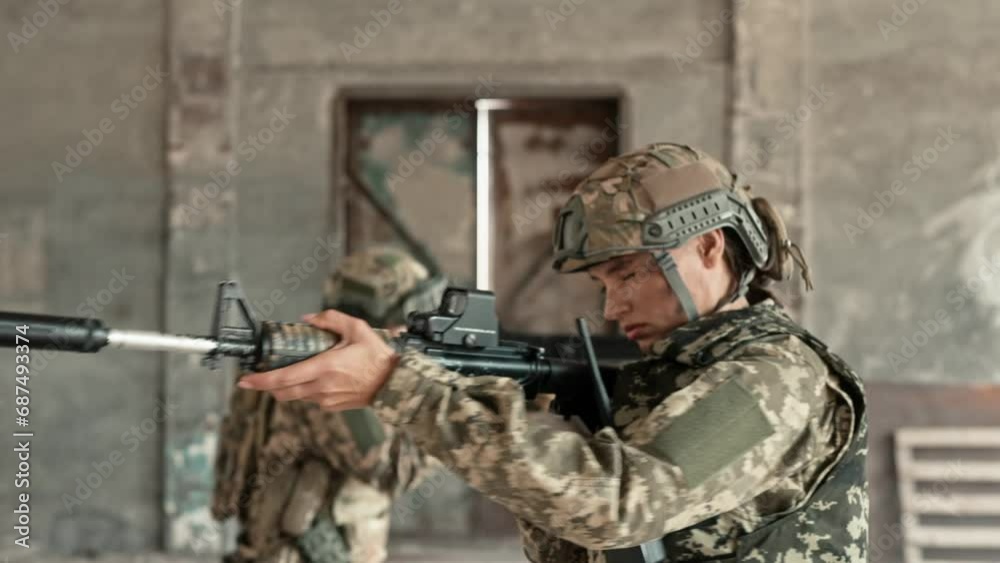 Soldiers with weapons moving in abandoned building during combat mission. Brave woman warrior with her partner taking cover from enemy attack. People opening metal door and going into smoky street. Soldiers with weapons moving in abandoned building during combat mission. Brave woman warrior with her partner taking cover from enemy attack. People opening metal door and going into smoky street.