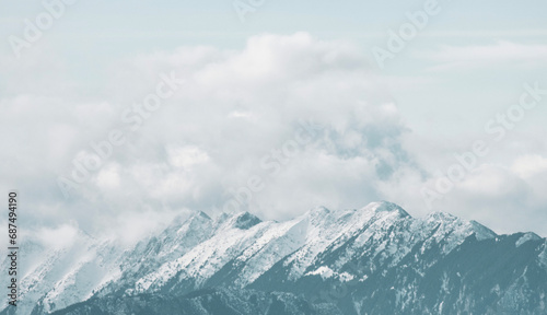 Majestic snowy peaks pierce the sky, their pristine white slopes glistening in the sunlight. The crisp, pure snow blankets the rugged mountains, creating a breathtaking vista. © daniel