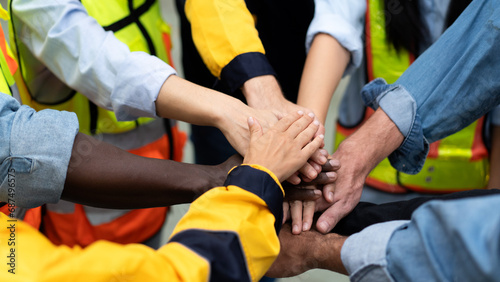 group of multiracial colleagues joining hands in morning meeting before going to work at a manufacturing industrial factory  teamwork of diverse worker stacking hands together motivate team building