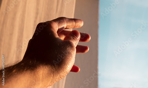 Hand pointing towards the sun