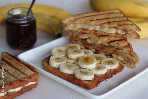 Sumptuous honey banana toast sandwich, golden bread layers with fresh sliced bananas, drizzled with sweet honey