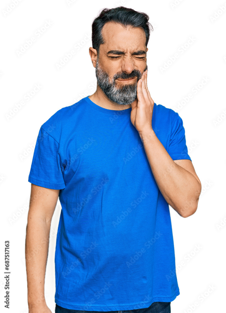 Middle aged man with beard wearing casual blue t shirt touching mouth with hand with painful expression because of toothache or dental illness on teeth. dentist
