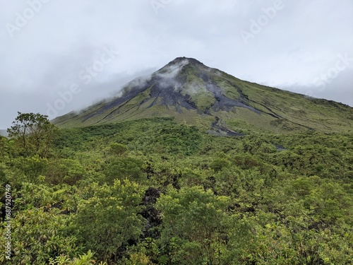 Arenal Volcano with cloud surrounding the summit in La Fortuna, Costa Rica. Green foliage and tropical jungle. 