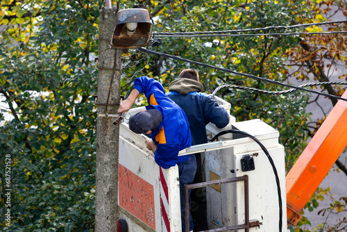 Electricians repair an electric pole after a storm.