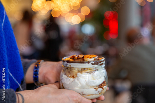 Woman holding banana dessert with bokeh effect lights in the background