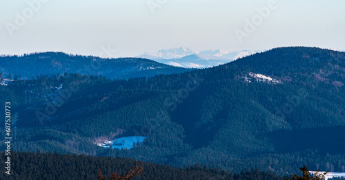 Nearer hills of Moravskoslezske Beskydy mountains and peaks of High Tatras mountains on the background from hiking trail to Lysa hora hill in winter Moravskoslezske Beskydy mountains photo