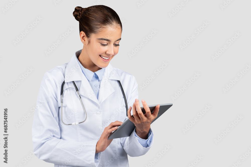 Smiling young european woman professional doctor or intern typing on tablet chatting Smiling young european woman professional doctor or intern typing on tablet chatting