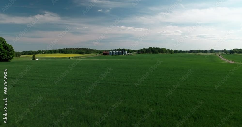 Aerial Shot Of Vehicle Moving By Silos Outside Small Factory, Drone Flying Forward Over Green Landscape On Sunny Day - Mariefred, Sweden Aerial Shot Of Vehicle Moving By Silos Outside Small Factory, Drone Flying Forward Over Green Landscape On Sunny Day - Mariefred, Sweden