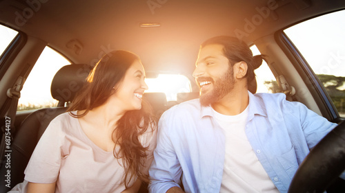 Laughing young arab couple enjoying car ride © Prostock-studio
