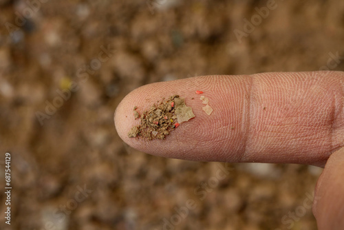 Foto Soil pollution, microplastic contamination in the soil on geologist's finger