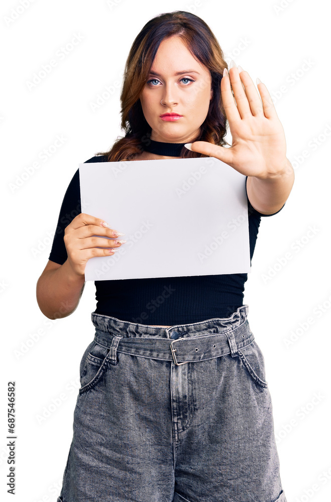 Young beautiful caucasian woman holding blank empty paper with open hand doing stop sign with serious and confident expression, defense gesture