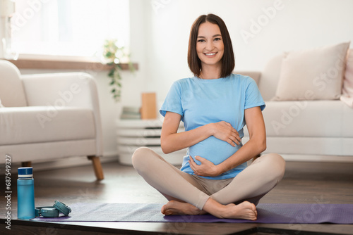 Pregnant young european woman doing morning yoga at home