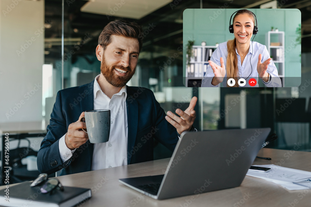 Fototapeta premium Handsome positive caucasian businessman talking with business partners via laptop