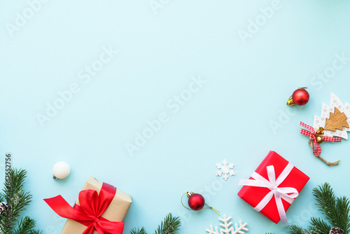 Christmas composition or greeting card. Christmas present box, candle and decorations at blue. Flat lay image with copy space.