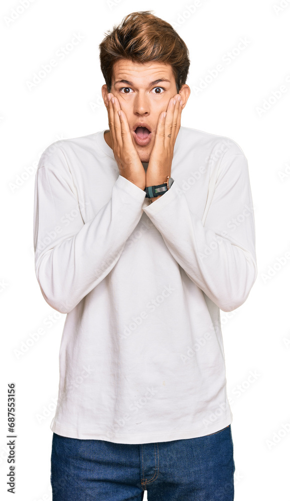 Handsome caucasian man wearing casual white sweater afraid and shocked, surprise and amazed expression with hands on face Handsome caucasian man wearing casual white sweater afraid and shocked, surprise and amazed expression with hands on face