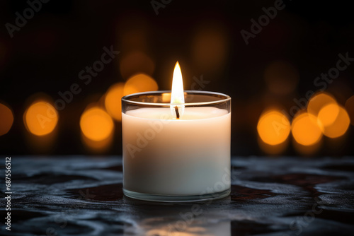 Lighted candles are placed on the table in front of a blurred light spot background