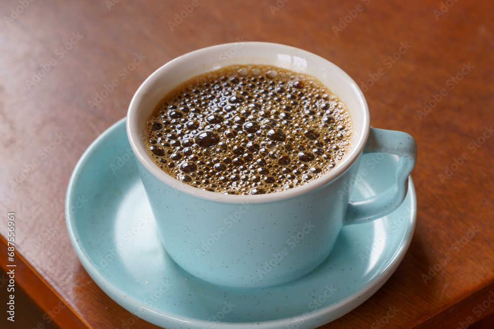 Coffee black in a cup over natural light