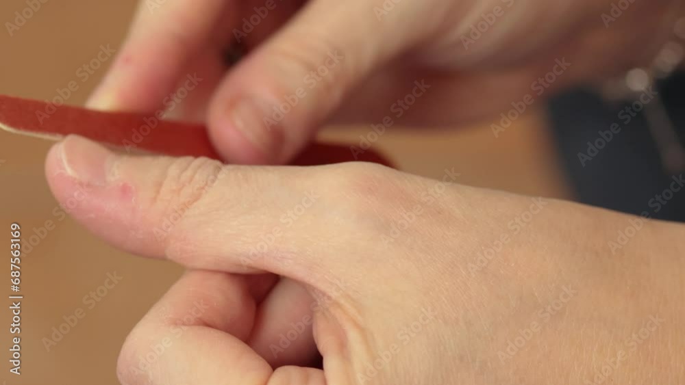 gros plan sur les mains d'une femme se limant les ongles