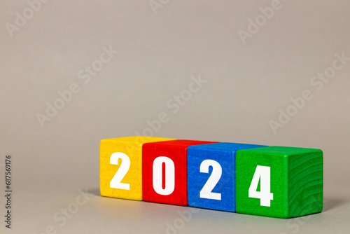 2024 Symbol. Starting the new year 2024. on colorful wooden cubes. The beginning of a new year. Preparation for the new year, new goals, challenges, life and business plans, gray backgroundcopy space photo