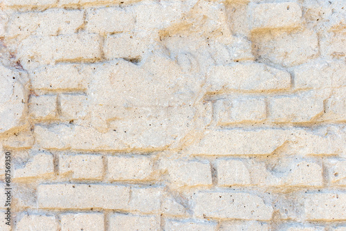 Abstract textured white wall background. Close-up view of old weathered brick wall with cement remains in a sunny day. Copy space for your text. Architecture backdrops theme.