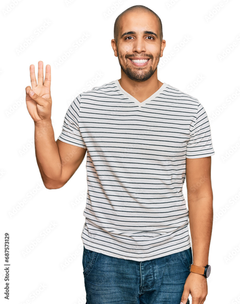 Naklejka premium Hispanic adult man wearing casual clothes showing and pointing up with fingers number three while smiling confident and happy.