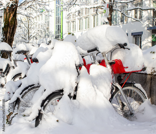 Bicycles covered in snow parked in a residential area during a December snowfall in Munich, Germany