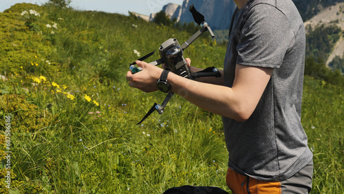 A man holds a quadrocopter in his hands, preparing it for flight. Launching a drone on a mountain hike. Commercially unmanned aerial vehicle.