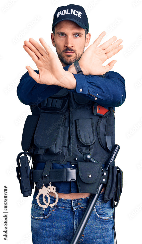 Young handsome man wearing police uniform rejection expression crossing arms doing negative sign, angry face Young handsome man wearing police uniform rejection expression crossing arms doing negative sign, angry face
