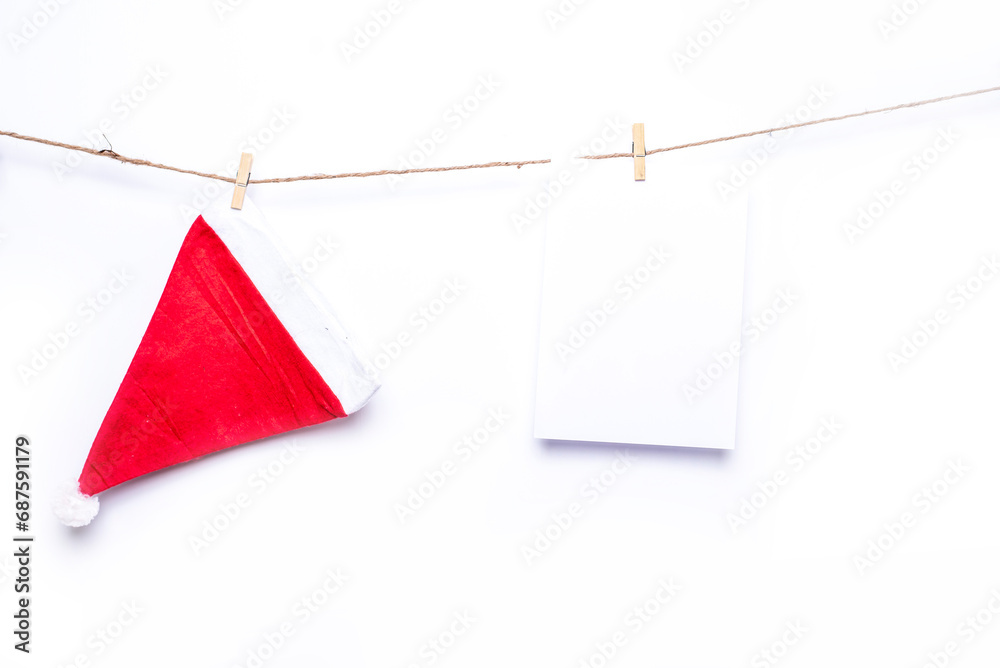 Santa hat and two blank paper are  hanging on isolate white background