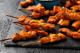 Grilled chicken fillet on skewers with white sauce on rustic stone board