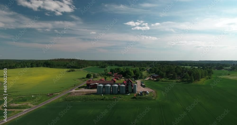 Aerial Scenic View Of Silos And Small Factory On Green Landscape, Drone Flying Forward During Sunny Day - Mariefred, Sweden Aerial Scenic View Of Silos And Small Factory On Green Landscape, Drone Flying Forward During Sunny Day - Mariefred, Sweden