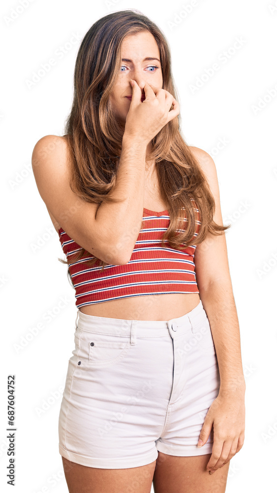 Beautiful caucasian young woman wearing casual clothes smelling something stinky and disgusting, intolerable smell, holding breath with fingers on nose. bad smell Beautiful caucasian young woman wearing casual clothes smelling something stinky and disgusting, intolerable smell, holding breath with fingers on nose. bad smell