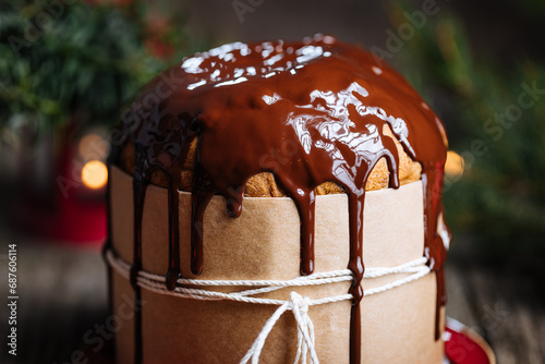 Christmas Panettone Cake with Melted Chocolate on Rustic Wooden Board and Festive Decorations - Holiday Dessert from Milan, Italy. 