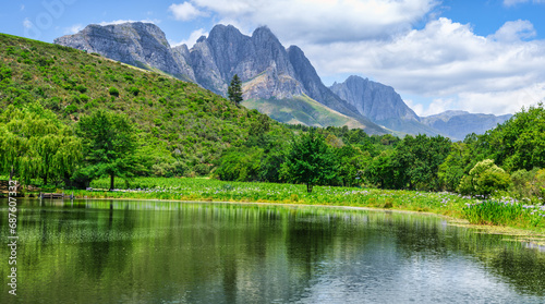Panorama shot of Stark-Conde Wines lake and The Jonkershoek Mountains range in the background with Stellenbosch Mountain peak, Cape Town, South Africa