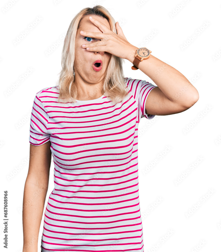 Young caucasian woman wearing casual clothes peeking in shock covering face and eyes with hand, looking through fingers with embarrassed expression. Young caucasian woman wearing casual clothes peeking in shock covering face and eyes with hand, looking through fingers with embarrassed expression.