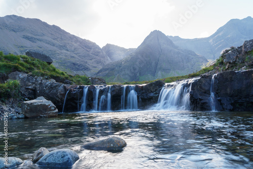 Fairy pool waterfalls and distant mountains in the Isle of Sky. Blurred water and foreground rocks.
