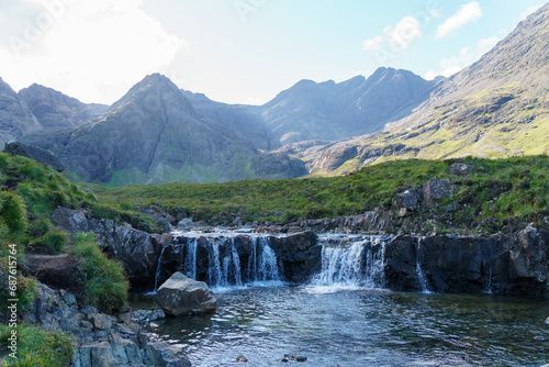 Fairy pool waterfalls and distant mountains in the Isle of Sky. Wide view of falls.
