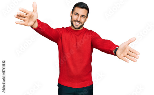 Young hispanic man wearing casual clothes looking at the camera smiling with open arms for hug. cheerful expression embracing happiness.