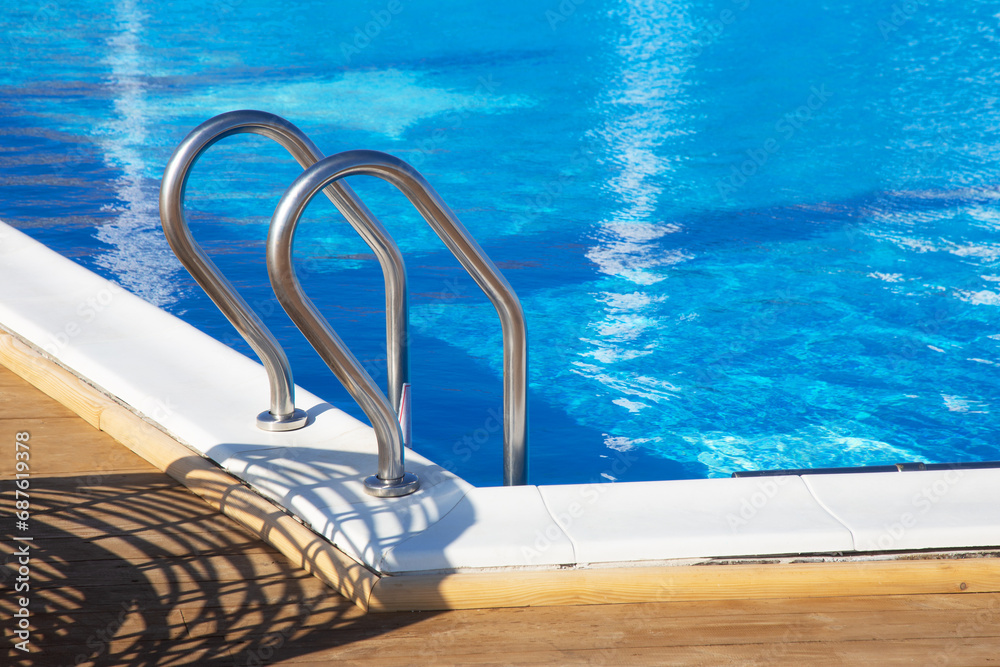 Modern white rattan furniture to create an outdoor pool in living room by sea. Luxurious swimming pool with white fashionable sun loungers on the beach. Landscape, interior for luxury holidays Modern white rattan furniture to create an outdoor pool in living room by sea. Luxurious swimming pool with white fashionable sun loungers on the beach. Landscape, interior for luxury holidays