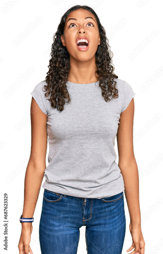 Young african american girl wearing casual clothes angry and mad screaming frustrated and furious, shouting with anger. rage and aggressive concept. Young african american girl wearing casual clothes angry and mad screaming frustrated and furious, shouting with anger. rage and aggressive concept.