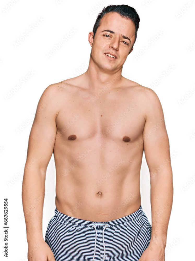 Handsome young man wearing swimwear shirtless in shock face, looking skeptical and sarcastic, surprised with open mouth Handsome young man wearing swimwear shirtless in shock face, looking skeptical and sarcastic, surprised with open mouth