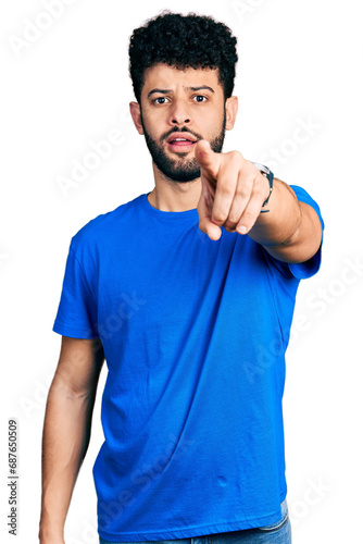 Young arab man with beard wearing casual blue t shirt pointing displeased and frustrated to the camera, angry and furious with you