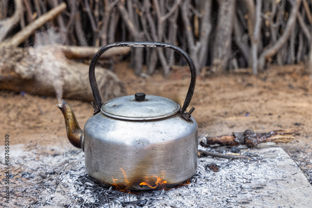 aluminum teapot on open fire in the outdoors kitchen, african village aluminum teapot on open fire in the outdoors kitchen, african village