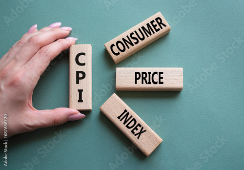 CPI - Consumer Price Index symbol. Concept word CPI on wooden blocks. Businessman hand. Beautiful grey green background. Business and CPI concept. Copy space. photo