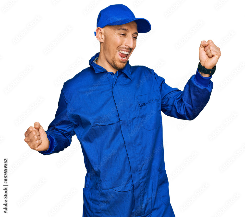 Bald man with beard wearing builder jumpsuit uniform dancing happy and cheerful, smiling moving casual and confident listening to music
