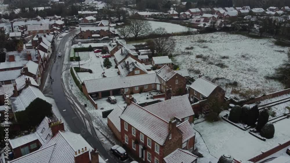 Drone shot 50fps. Middle-class suburban houses in English market town village. Winter, snow, cold, freezing weather. Drone shot 50fps. Middle-class suburban houses in English market town village. Winter, snow, cold, freezing weather.