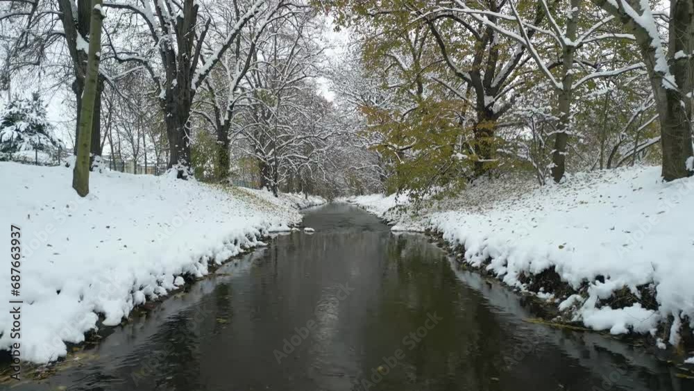 Fly over winter city stream calm river covered in snow, drone Fly over winter city stream calm river covered in snow, drone