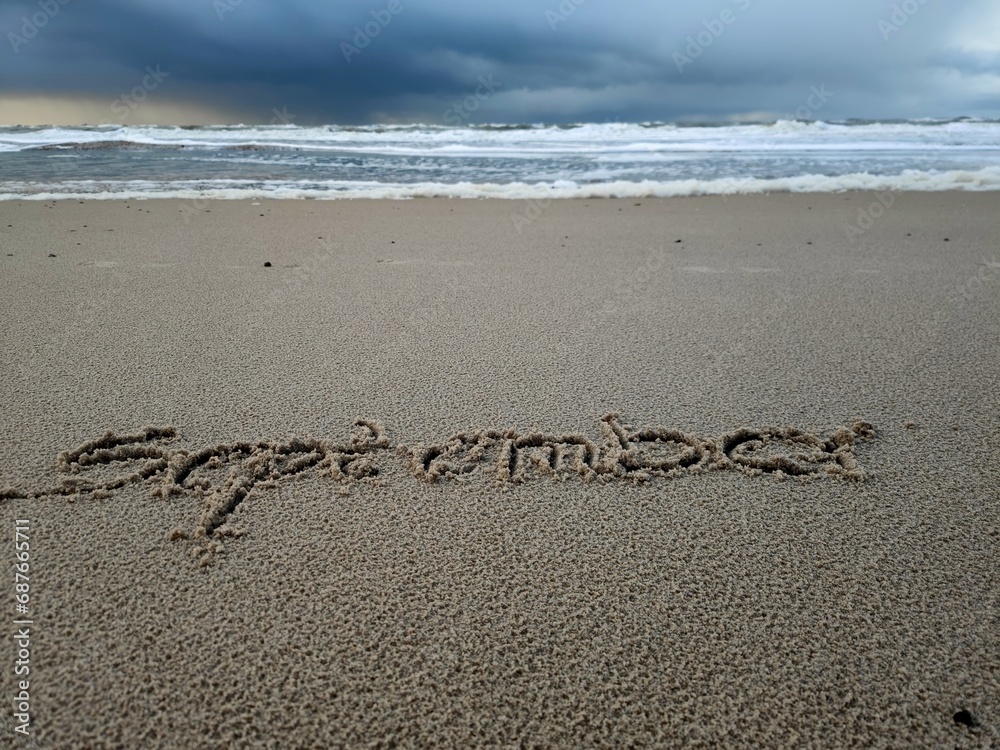 Fototapeta premium September als Wort im Strandsand