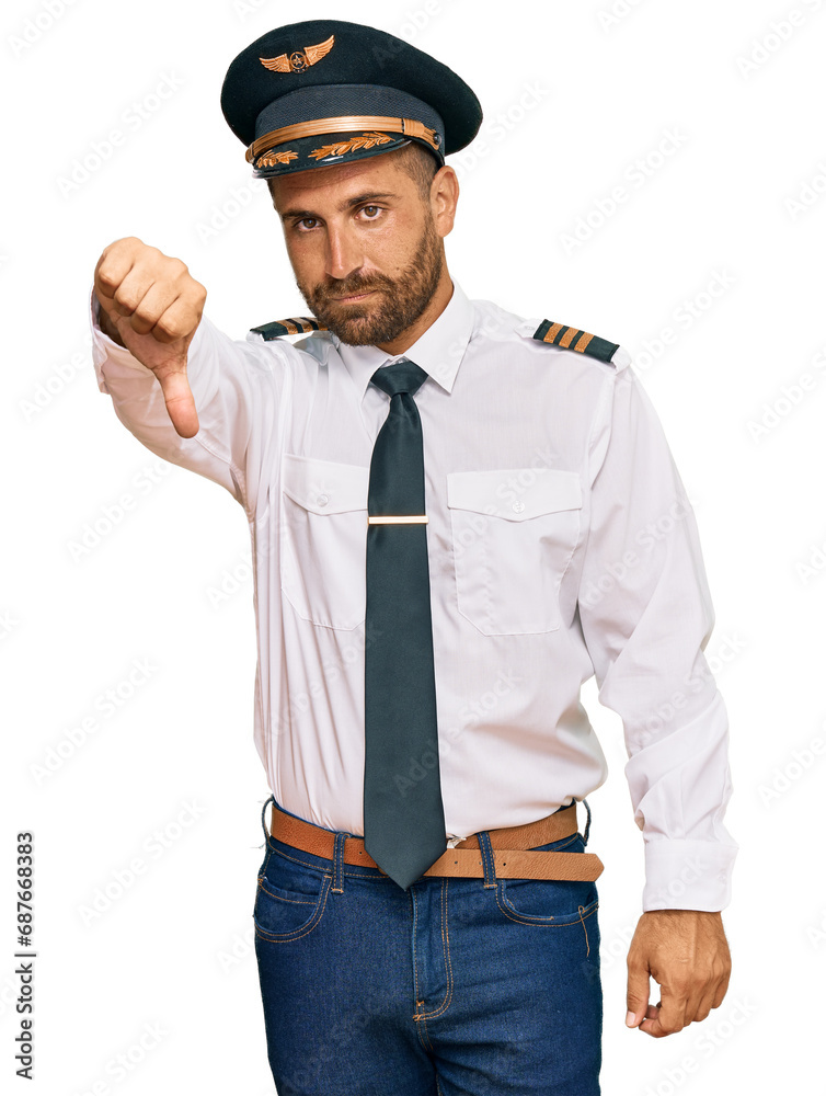 Handsome man with beard wearing airplane pilot uniform looking unhappy and angry showing rejection and negative with thumbs down gesture. bad expression. Handsome man with beard wearing airplane pilot uniform looking unhappy and angry showing rejection and negative with thumbs down gesture. bad expression.